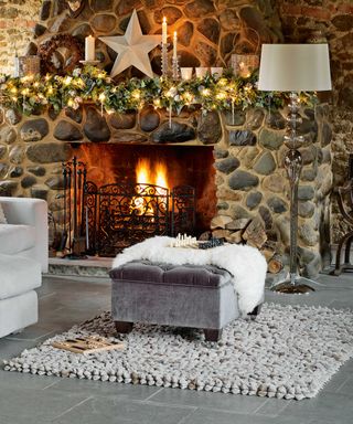christmas living room with fireplace and grey storage ottoman