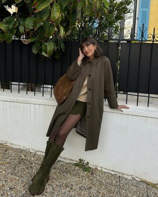 french woman wearing miniskirt, long jacket, and tall suede boots