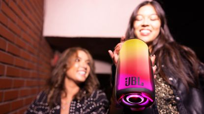 JBL Pulse 5 review: woman holding light up speaker 