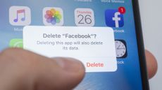 Picture of a thumb hovering over a smartphone screen showing the user is about to delete the Facebook app