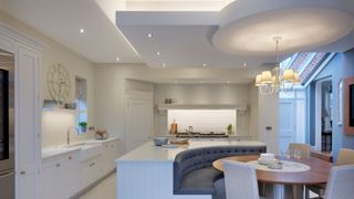 a kitchen with built-in island seating and accent lighting used throughout