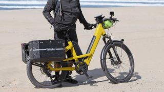 Man standing on sandy beach with Benno 46er e-bike