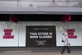 A House of Fraser shop with a poster saying 'This store is now closed' in the window