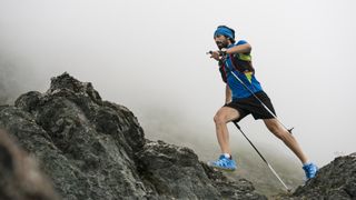 best trekking poles: trail runner using poles