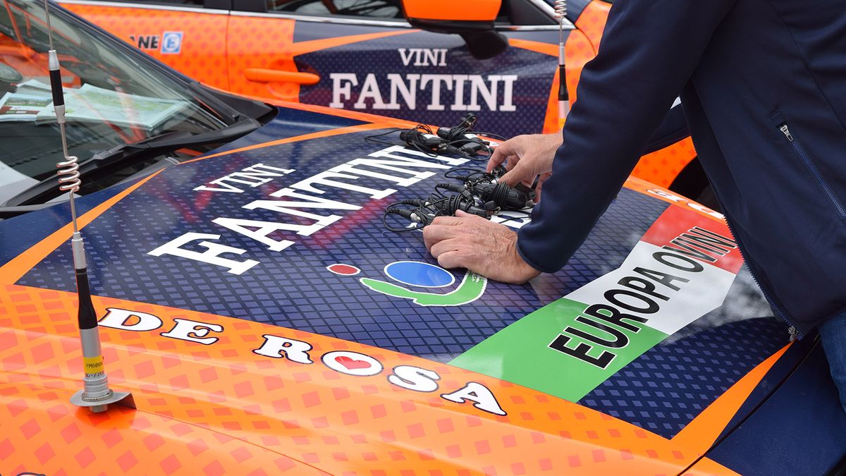 A Nippo Vini Fantini directeur lines up the team radios ahead of a stage start