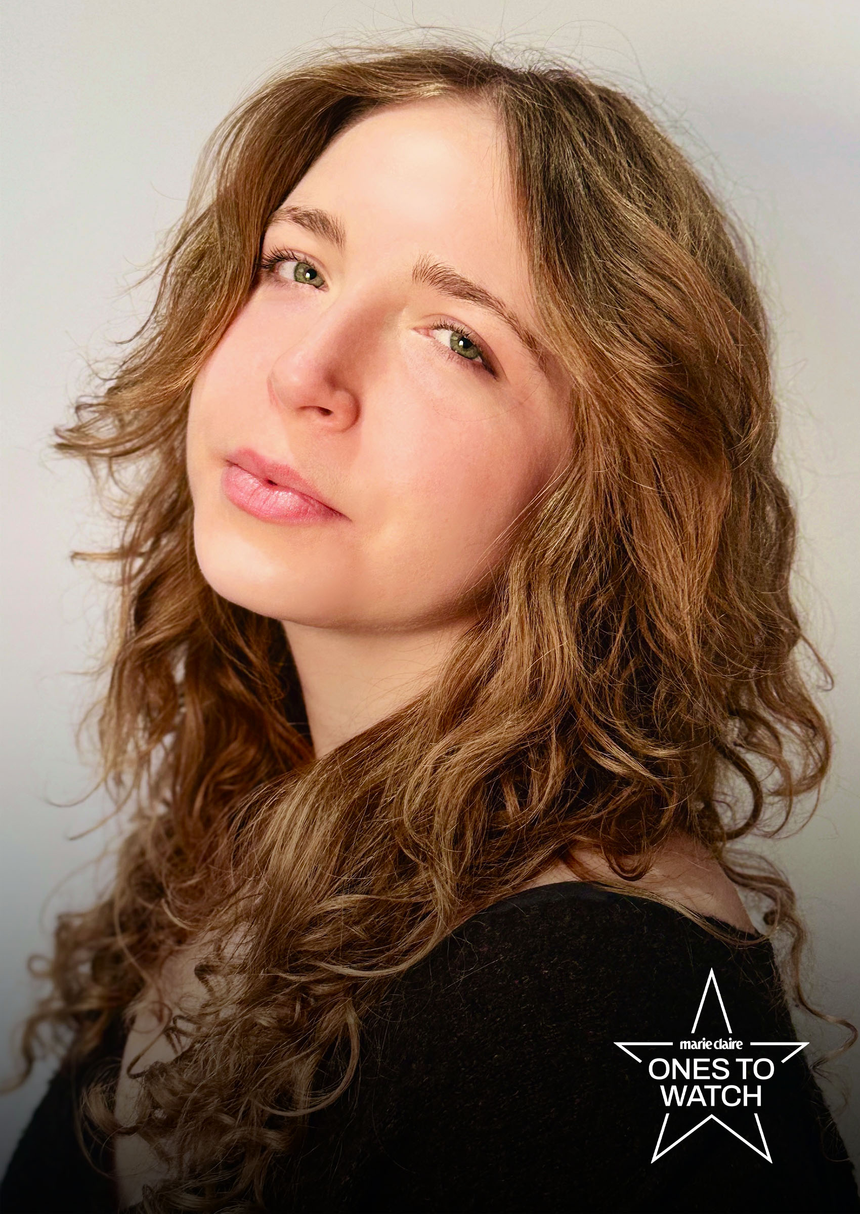 writer raffi donatich poses leaning her head back and draping her hair over her shoulders wearing a black top