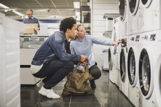 Man buying new washing machine for how to save money on electric bills