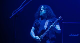 Fredrik Åkesson is bathed in dark blue light as he plays his PRS live onstage with Opeth in Mexico