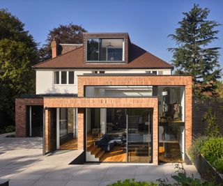 interlocking brick extensions with lowered ground floor and large sections of glazing