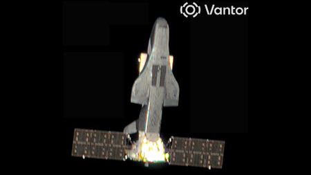 on a black background, a T-shaped object consisting of a winged aircraft-like spacecraft jointed to a satellite with two wing-like solar panels