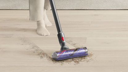 One of the cheapest Dysons, a Dyson V8, cleaning a hard wood floor of dust