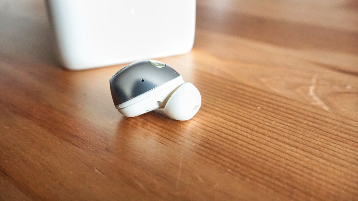 Sennheiser Momentum True Wireless 5 in white, showing details of the buds held in a hand