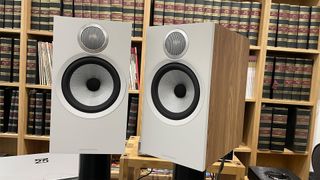 Bowers & Wilkins 606 S3 speakers in light oak finish with bound books in background
