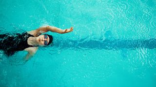 Woman doing backstroke in a swimming pool.