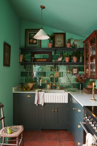 Small, cozy kitchen with dark green cabinets by Devol
