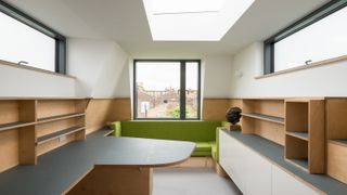 Mansard loft conversion with multiple surfaces and green sofa