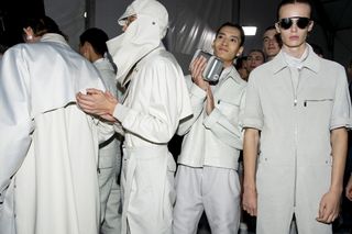 A group of models backstage in all-white outfits