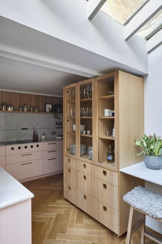 Small L-shaped kitchen with pink and wooden cabinetry