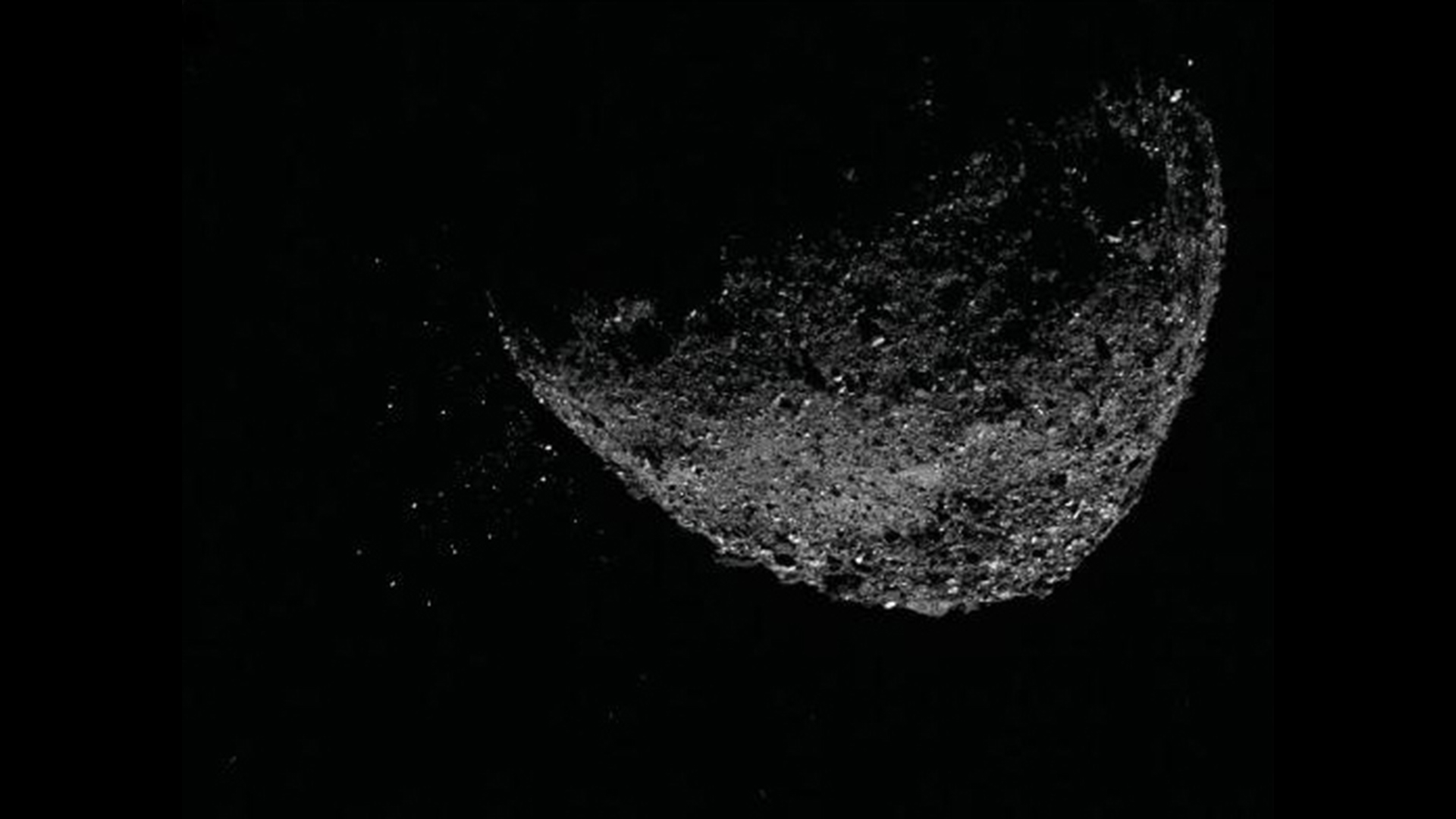 Αυτή η άποψη του αστεροειδούς Bennu που εκτοξεύει σωματίδια από την επιφάνειά του στις 6 Ιανουαρίου 2019, δημιουργήθηκε με το συνδυασμό δύο εικόνων που τραβήχτηκαν από τον απεικονιστή NavCam 1 στο διαστημόπλοιο OSIRIS-REx της NASA: μια εικόνα σύντομης έκθεσης, που δείχνει καθαρά τον αστεροειδή και μια εικόνα μακράς έκθεσης .  - Έκθεση της εικόνας (πέντε δευτερόλεπτα) που δείχνει καθαρά τα σωματίδια.