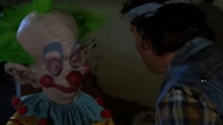 A Killer Klown getting ready to knock a guy's block off in Killer Klowns From Outer Space