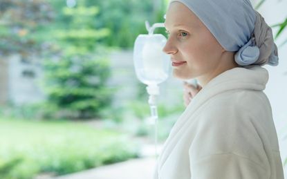 Woman in white robe smiling and looking out the window