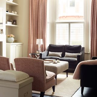 Neutral living room with built-in alcove storage and a smart grey sofa with pink curtains