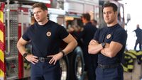 Buck with his hands on his hips and Eddie crossing his arms at the firehouse on 9-1-1.