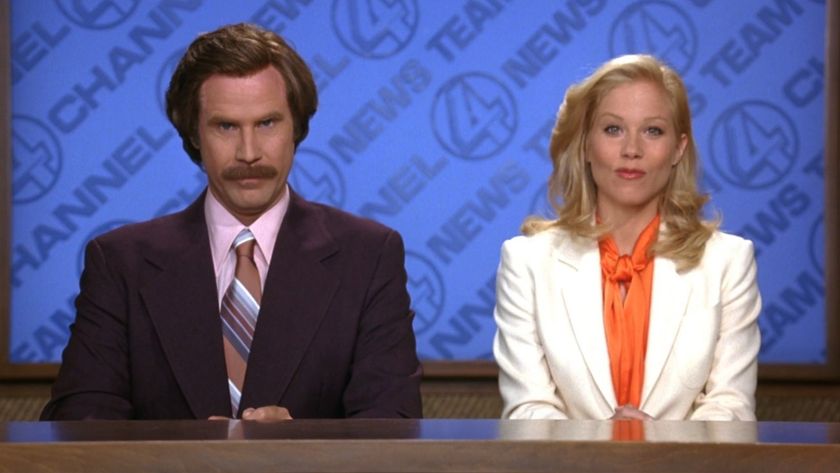 Will Ferrell and Christina Applegate sitting next to each other at the new desk.