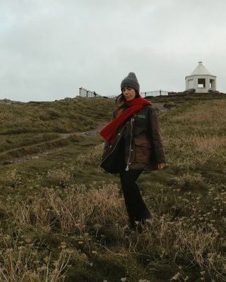 @_jessicaskye wearing a wax country coat, scarf and jeans in the countryside