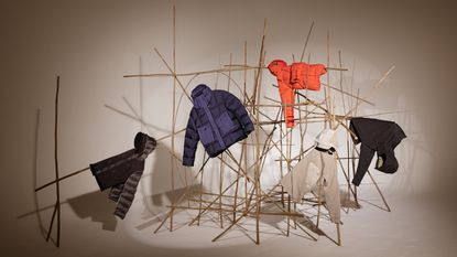 Ten c A/W 2022 clothing displayed on installation of sticks