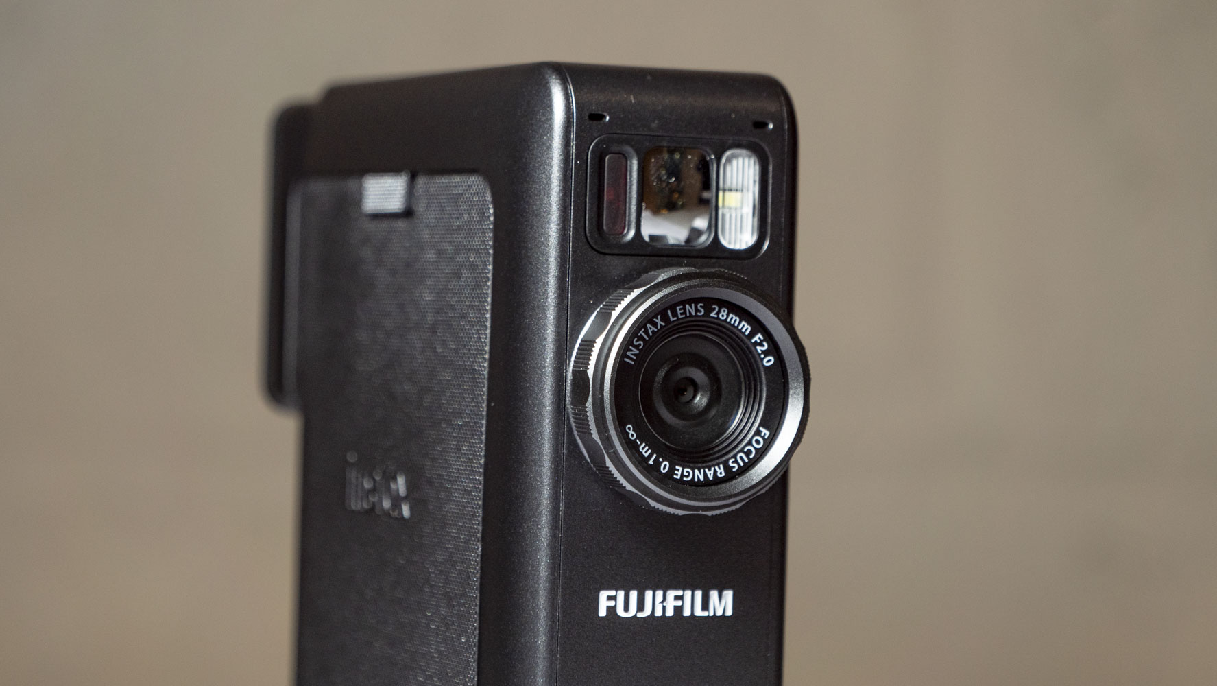 Fujifilm Instax Mini Evo Cinema on a white wooden surface