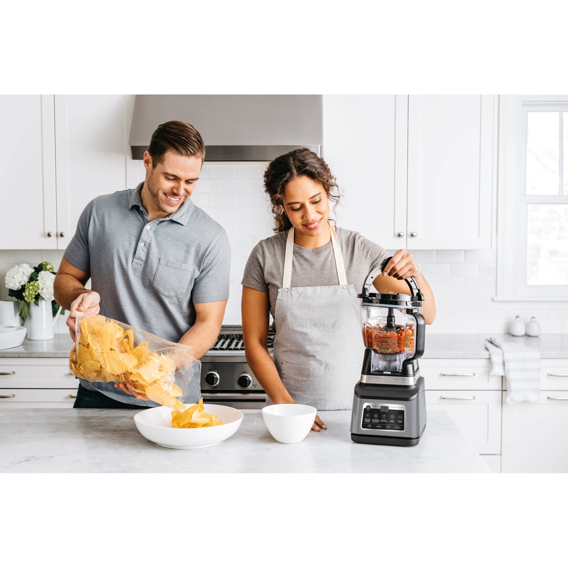 Image of two people in the kitchen using Ninja kitchen appliances
