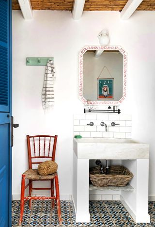 Bathroom in a Greek villa with white washed walls and patterned tile floors