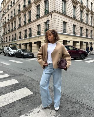 Woman wearing jeans a camel jacket