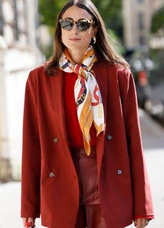 Woman wearing a neckerchief with a red coat and sunglasses