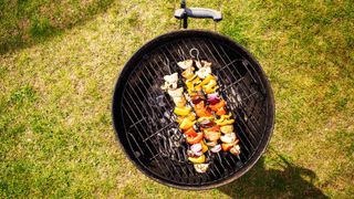 aeiral view of a BBQ with three chicken skewers on it