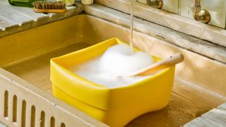 Butler sink with washing up bowl filled with soapy water