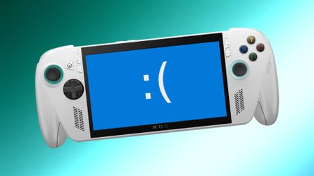 Asus ROG Xbox Ally with blue screen and sad face on display and two tone teal backdrop. 