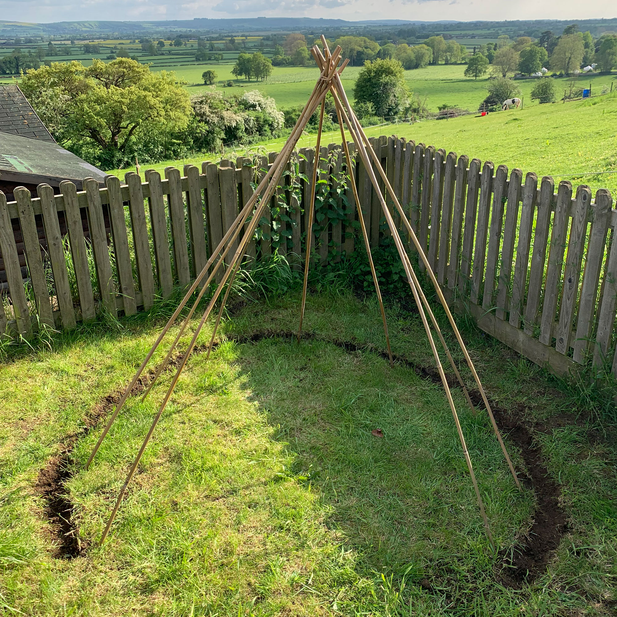 Wooden teepee structure in country garden