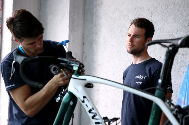 Mark Cavendish watches the mechanic do his thing