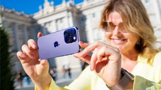 Woman holding out an iPhone 14 Pro to take a photo