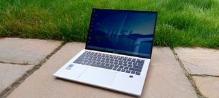 A silver MSI Prestige 14 Evo B13M laptop sitting on a patio rock