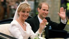 The newly-wed British royal couple Prince Edward (R) and Sophie Rhys-Jones greet wellwishers on their way from Windsor Castle after the wedding ceremony 19 June 1999. The royal couple took a brief ride through the historic town of Windsor. 