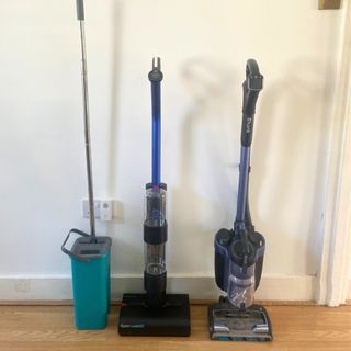 Dyson WashG1 standing in between a Beldray mop and a Shark vacuum