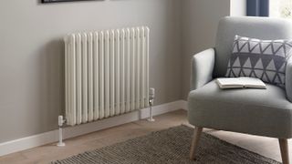 column radiator with low skirting boards and cream armchair