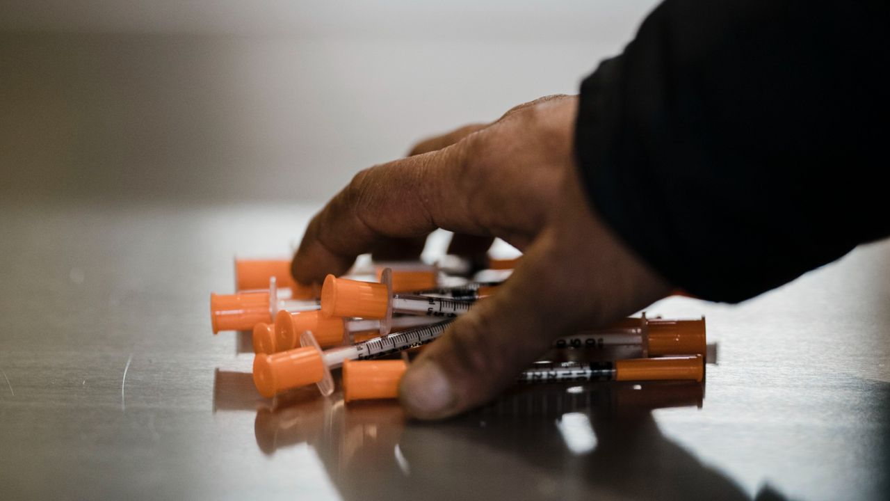 A man picks up syringes at a safe injection site in New York City.