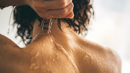 A woman showering off a body scrub