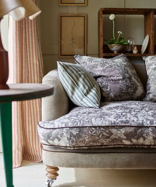 close up image of a grey sofa with mix and match seat cushions and pillow backs in a grey floral