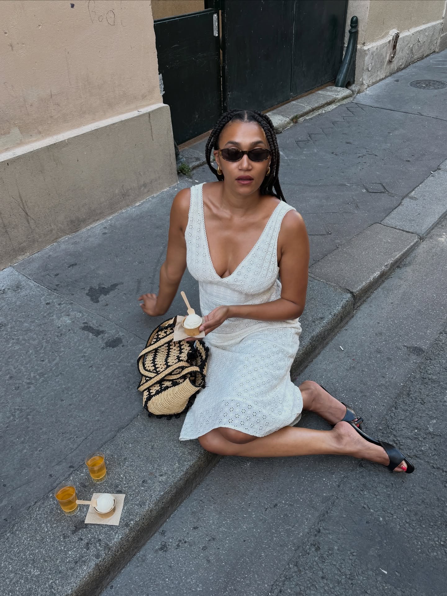 lena farl wears a white summer dress, black mules and straw basket bag