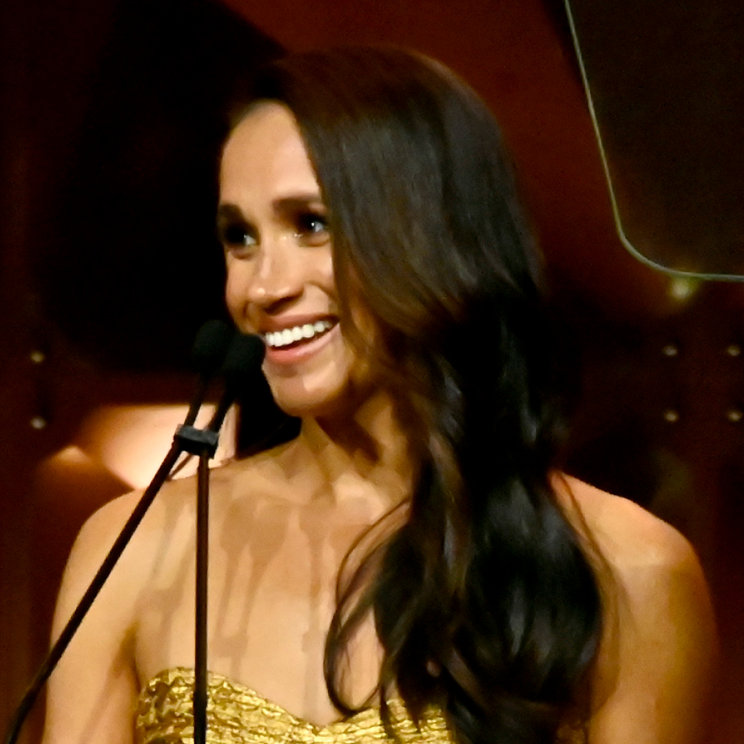 Meghan Markle wears a strapless gold cut-out gown and has long brown hair